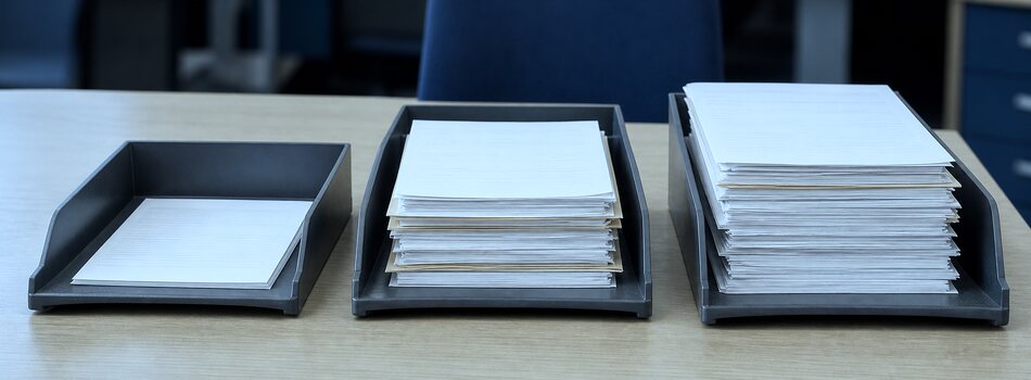 Three document trays with small, medium, and large paper batches on a table